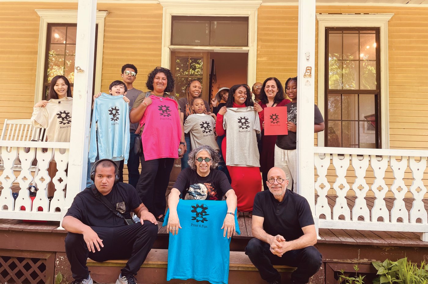 Families and children at the Print 4 Fun event, holding the shirts they printed